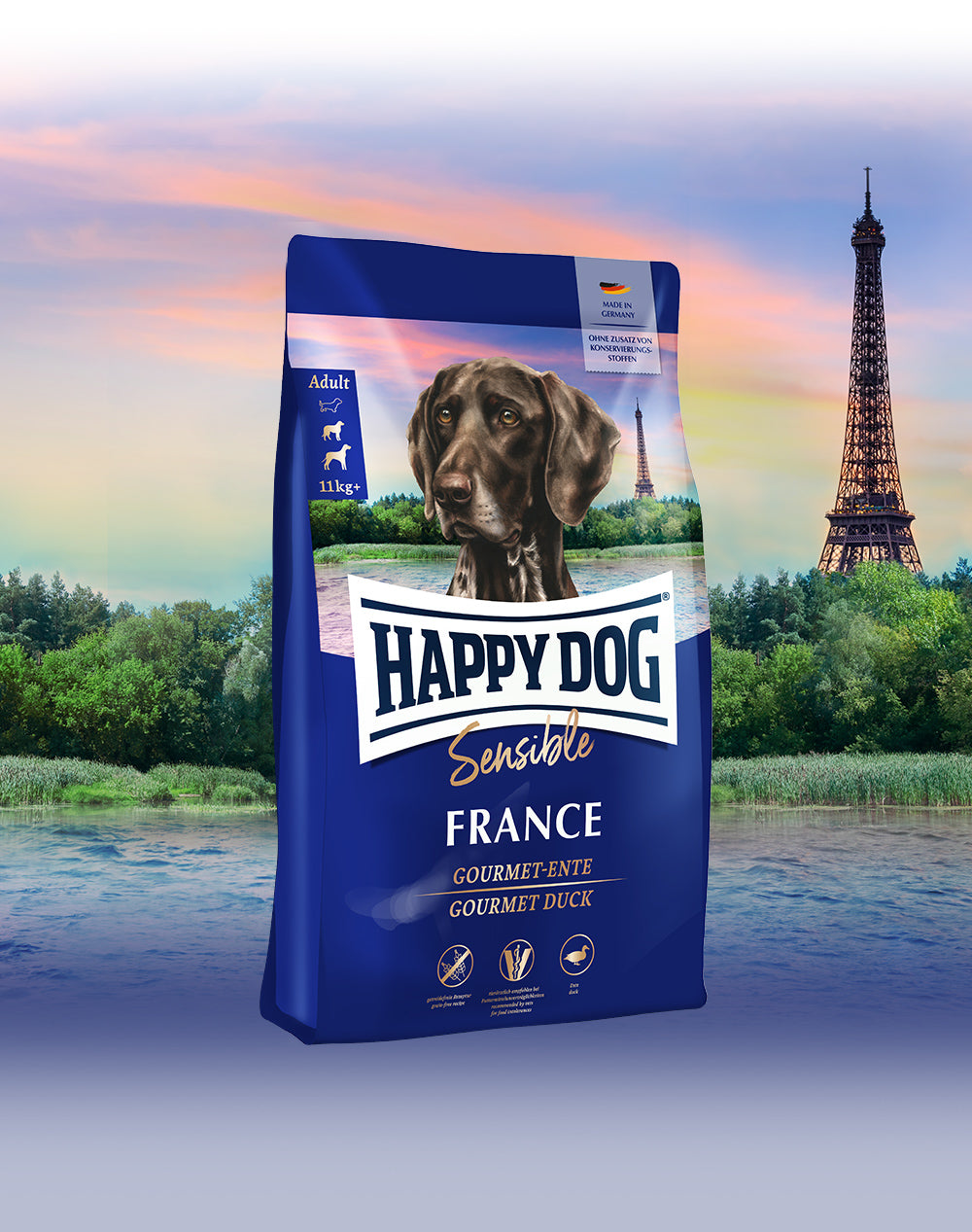 Das Hundefutter Happy Dog Sensible France vor einer französischen Landschaft mit dem Eiffelturm im Hintergrund.